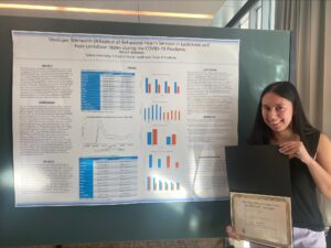 Niamh Brennan holds her first place award at the Delta Omega Poster Competition.